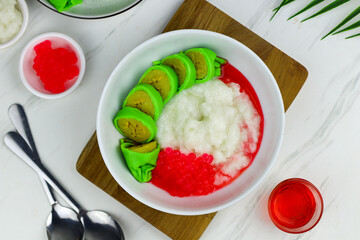 Es Pisang Ijo or Green banana ice, one of Indonesian popular dessert from east Sulawesi, Makassar. Es Pisang ijo made from banana coated with green flour dough, serve with red syrup.