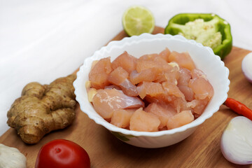 Side view of meat dishes, burger, fried chicken breast, roasted vegetable chicken wings, with ketchup and other spices on a wooden board, on white background.