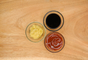 Set of different dip sauces top view. Bowls of many dipping sauces and condiments isolated on wooden background. ketchup, bbq sauce, ranch, mustard, ginger and garlic paste.