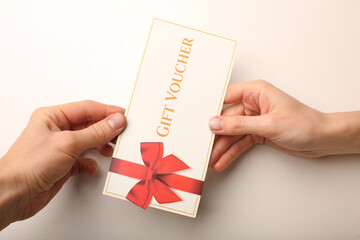 Top view of woman holding gift voucher with 500 value lettering on white background