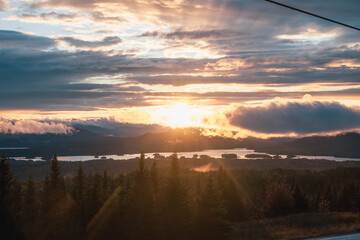 high point of view of a  land with a pine tree forest and a lake in the valley during a bright and...