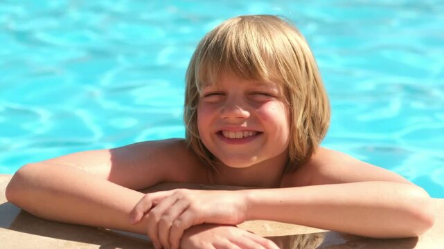 Portrait smiling boy in swimming pool, child in swimming glasses. Summer travel hotel vacation or classes. Kid relaxing in pool. Childboy swimming in blue water. activity, watersports.