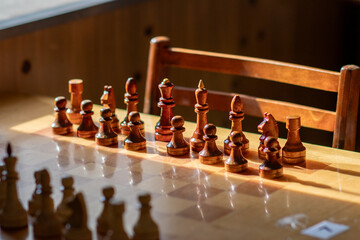 Wooden chess on a board in an old club in the rays of the sun. Soft focus