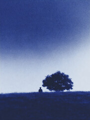 Person sitting quietly under a tree, gazing into the distance on a serene hillside location in the early evening light