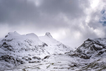 winter panorama of a Pyrenean landscape with snow-capped mountains and a small isolated farmhouse in the middle of the snowfall, Portalet Pass, France