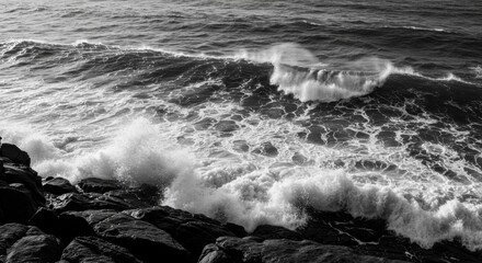 Monochromatic ocean waves crashing against rocky coastline, creating dramatic sea spray