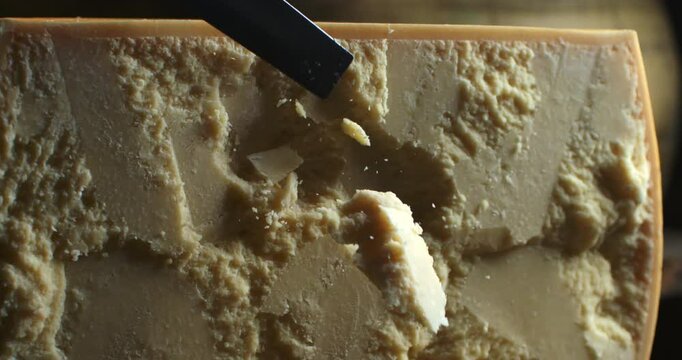 Cinematic Super slow motion macro of artisan cheesemaker controls quality of parmesan cheese during ripening process at production creamery dairy factory at 1000 fps.