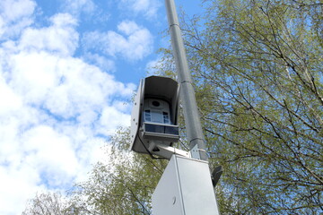 A surveillance camera hangs on a pole.
