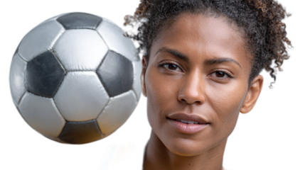 Focused Passion: A portrait of an athletic woman gazing intently as a soccer ball hovers near her face, perfectly capturing the energy, skill, and dedication that define her as a champion.