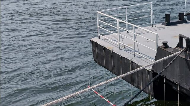 River landing stage at the quay wall against the background of a river