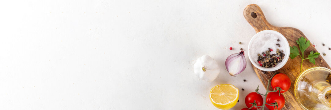Spices, black pepper, garlic, onion, greens and tomatoes, olive oil on white cooking table. Ingredients for cooking food on the white stone concrete background top view copy space. - Powered by Adobe