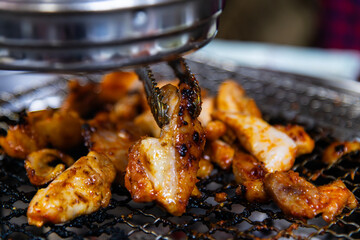 roasting spicy marinated-chicken meat on the charcoal grill