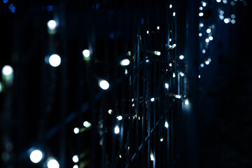 Close-up view of small and white LED lights strung along thin wires with bokeh effect