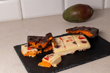 dubai chocolate bar with mango cubes and fresh passion fruit gourmet white chocolate with colorful splashes dessert mango passionfruit concept confectionery