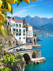 Scenic coastal road curves along cliffs from Amalfi to Atrani, Italy. Amalfi coast is popular travel and holyday destination in Italy. Ripe yellow lemons in foreground