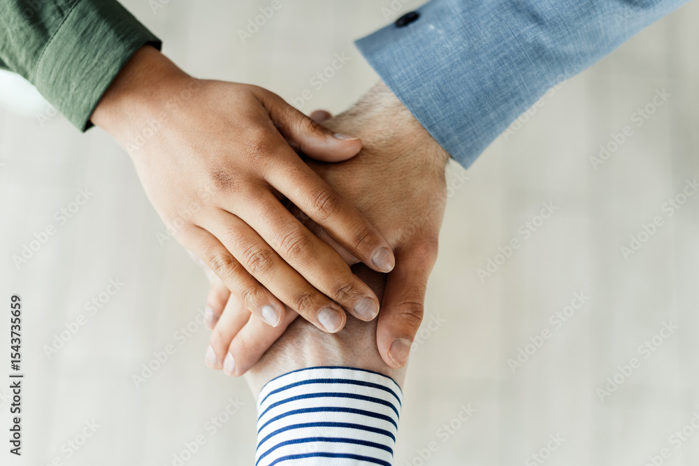 Poster collaborative teamwork represented through a close-up of hands stack symbolizing support and trust
