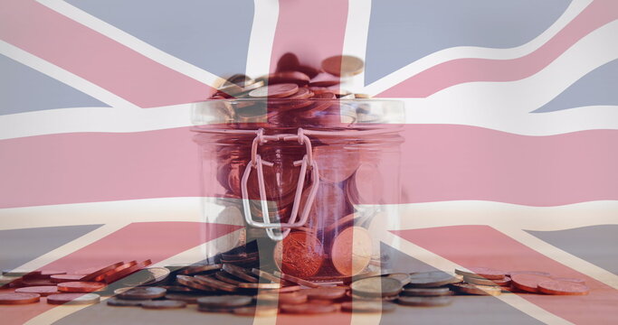 Fototapeta Displaying glass jar holding assorted coins on wooden tabletop, with Union Jack flag overlay