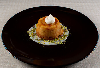 Savory Tart with Cream, Melted Cheese, and Pistachio Crumble on Black Plate