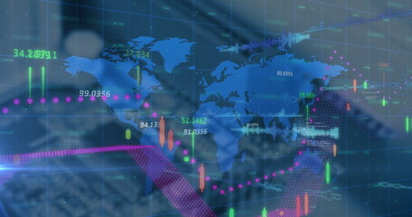 Interacting suited executive editing financial charts with stylus on screen at desk with world map