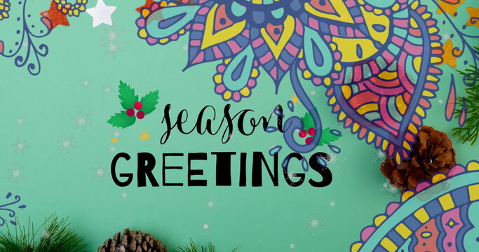 Fototapeta Displaying Season's Greetings lettering on mint-green background, with holly icon and pine cones