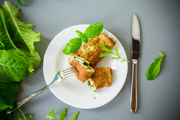 Omelette roll with greens on top on a white plate