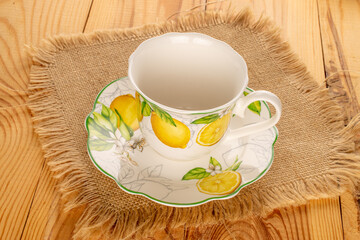 Ceramic cup on a ceramic saucer on a wooden table.