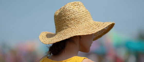 Woman wearing straw hat at sunny outdoor event