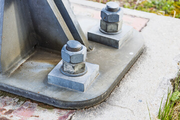 Heavy Duty Steel Bolts Securing Industrial Metal Structure to Concrete Base