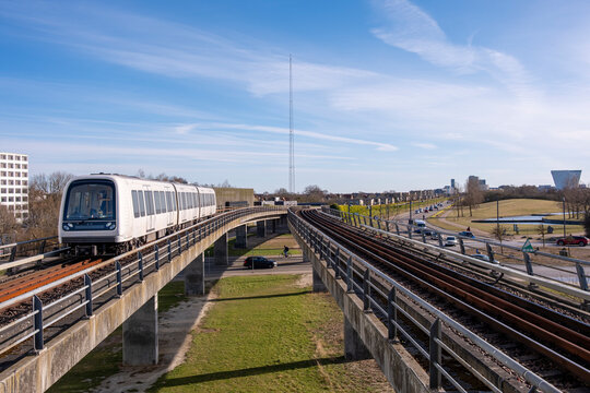 Front view of Copenhagen elevated metro arriving through double tracks in Havnestad, Denmark, public transport and urban design integration
