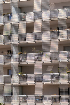 Repetitive facade pattern of concrete balconies and pixelated shadows in modern residential building, abstract architectural texture and rhythm