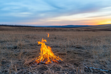 unextinguished fire among dry grass is a danger of a wild fire