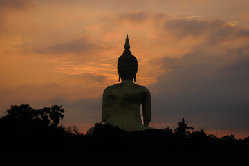 The largest golden Buddha statue with green rice field foreground at Wat Muang Temple in Ang Thong Province, Thailand.