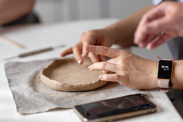 women's hands sculpt from clay