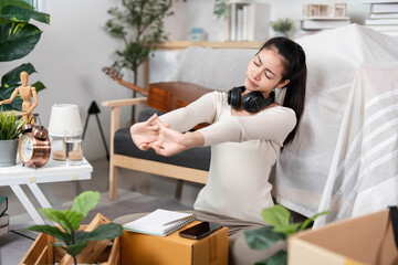 Moving and Stretching. Young woman relaxing and stretching at home during moving day.