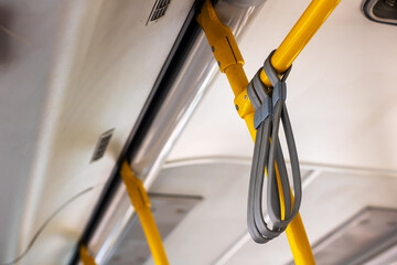 There is a yellow pole that has a gray strap securely attached to it