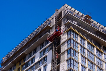 A building under construction with a blue sky behind it