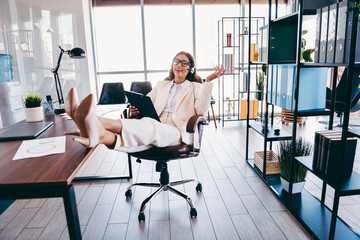 Confident businesswoman relaxing in her office chair while working in a brightly lit contemporary...