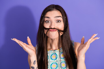 Playful young woman with a quirky hairstyle poses against a purple background, exuding fun and charm in a light-hearted mood