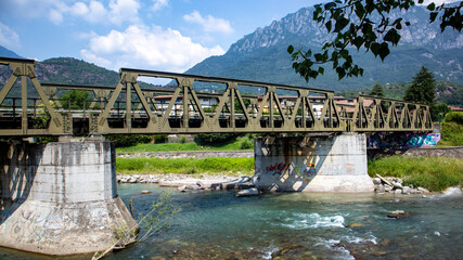 Metal Railroad Bridge Crossing a River with Mountains in the Background,Darfo, Boario Terme, Italy