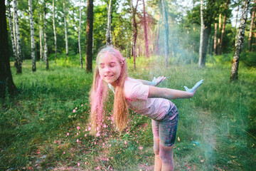 Caucasian preteen girl in casual outfit throws holi powder outdoors, eyes closed and smiling,...