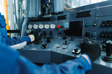 Mining equipment control panel with operator using levers and buttons in industrial setting