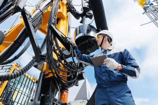Offshore worker inspect with tablet drilling rig for exploration of minerals for oil, gas. Concept smart AI online Industry