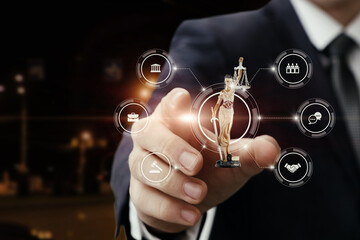 Businessman holding a figurine of justice at night