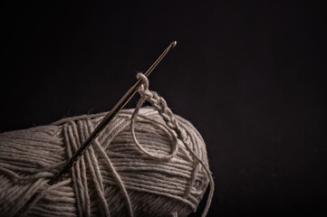 Needle threaded with yarn sits atop a spool, illustrating the art of sewing and the intricacies...