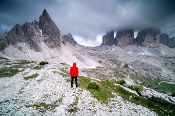 Traveler man looking at the top of Tre Cime di Lavaredo mountain. Extreme healthy lifestyle, hiking...