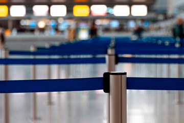 Close-up of a metallic barrier pole with blue retractable belts with others in behind located in an...