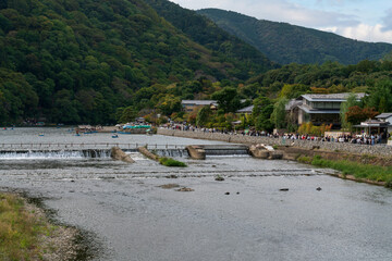Boating on the Katsura River in the Rankyo Gorge in the favorite vacation spot of Kyoto residents in Arashiyama district on a sunny autumn day, Kyoto, Japan