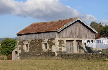 Obraz premium Old barn with clothes hanging and stone and wood facade in the countryside, Quintadona - Portugal 