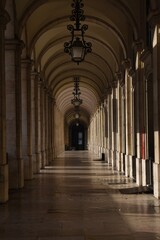 Fototapeta premium Symmetrical stone arcade with vaulted arches and shadows in Lisbon, Portugal