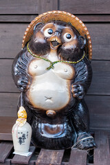 Ceramic statue of Tanuki, symbol of good fortune, in front of sake store, Takayama, Japan